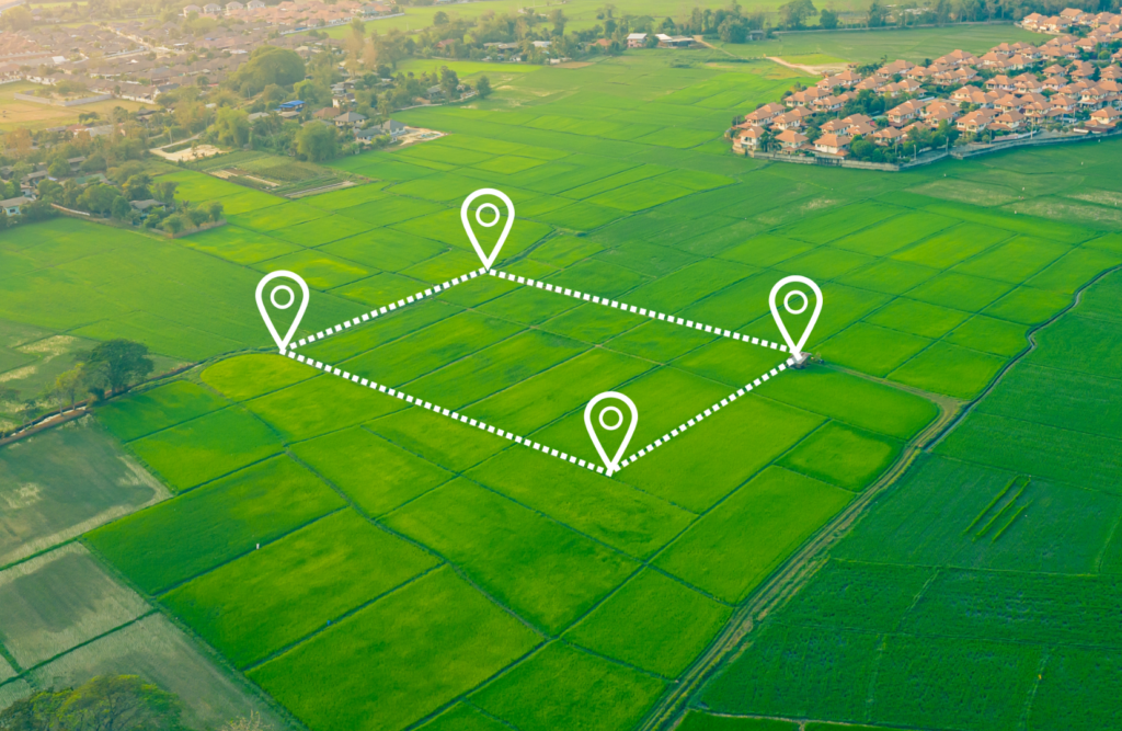 Vista aérea de área rural com marcações digitais de limites de terreno, representando processo de desmembramento e divisão de áreas para regularização imobiliária.