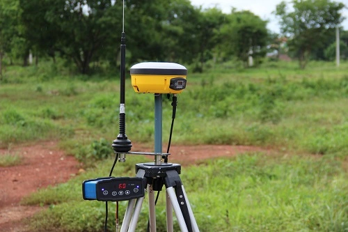 Equipamento GNSS RTK montado em tripé realizando medições geodésicas de alta precisão em área rural, utilizado para georreferenciamento e levantamentos topográficos.